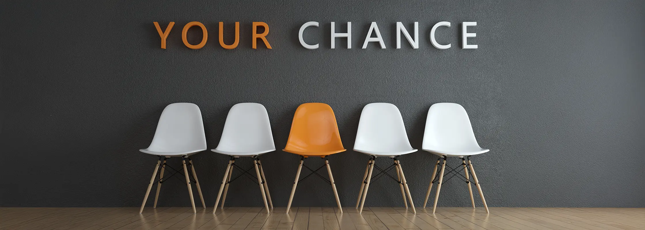 Fünf Schalenstühle vor einer dunklen Wand mit dem Schriftzug „Your Chance“
