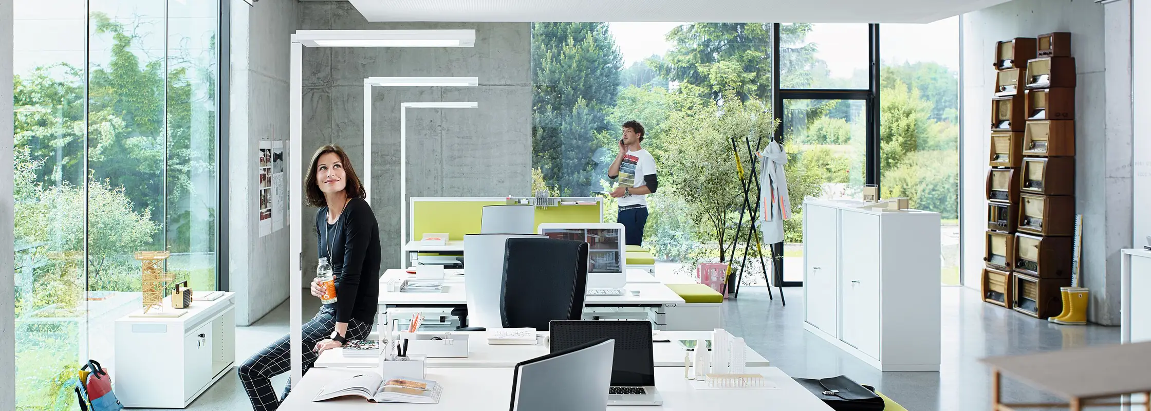 Büro an der Glasfassade mit Stehleuchten über den Arbeitsplätzen