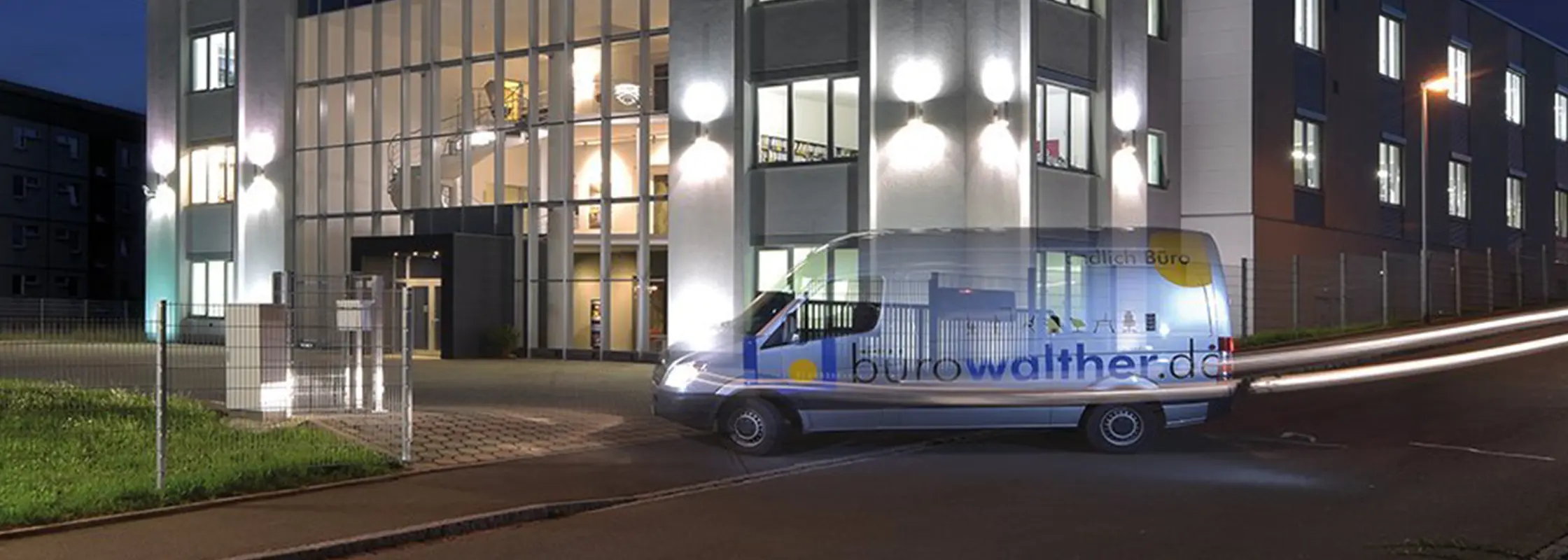 Das Firmengebäude bei Nacht mit einem beschrifteten Transporter davor