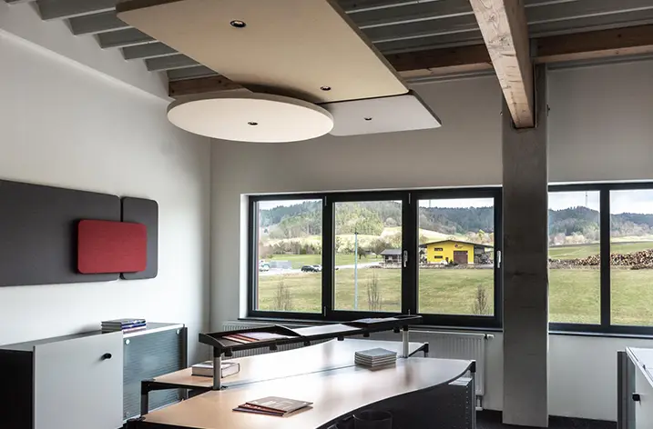 Büro mit rundem Deckensegel, roter Wandtafel und Blick ins Grüne