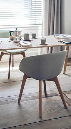 Besprechungstisch aus Holz mit Schalenstühlen am Fenster