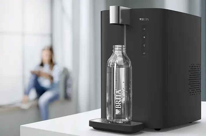 Schwarzer Brita-Wasserspender mit Glasflasche auf einer Ablage