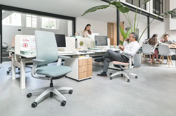 Bürolandschaft mit Drehstühlen, Arbeitsplätzen und Besprechungsbereich