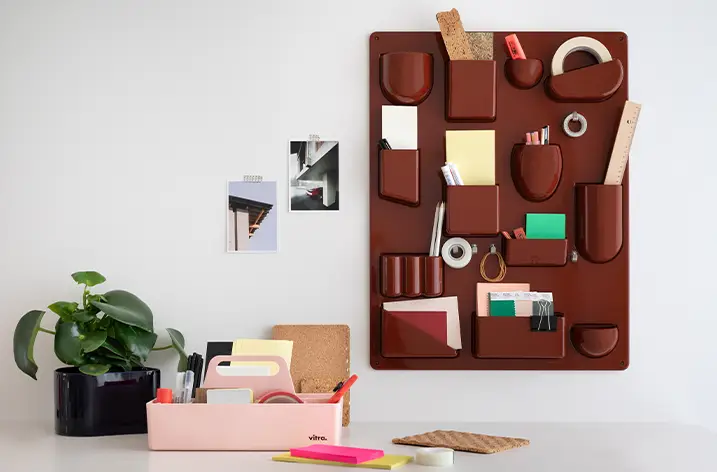 Rotbraunes Wandorganizer-Board mit Schreibtischzubehör über einem Schreibtisch