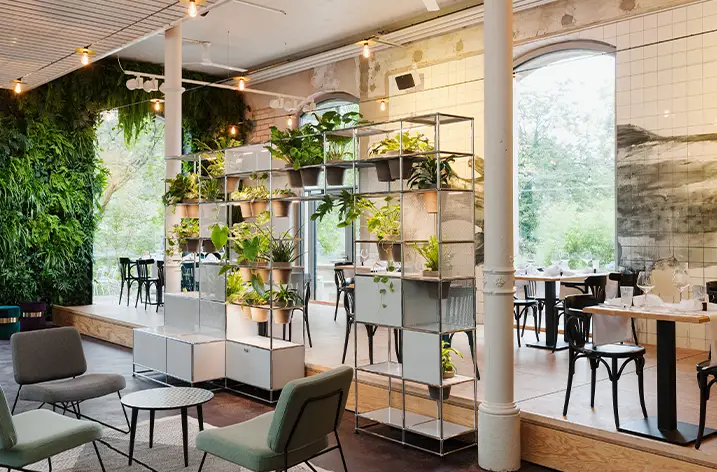 Bepflanztes USM-Haller-Regal als Raumteiler in einem Restaurant