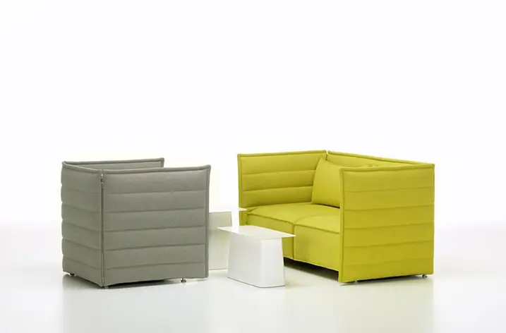 Gelbes Hochlehnersofa und grauer Sessel mit weißem Beistelltisch