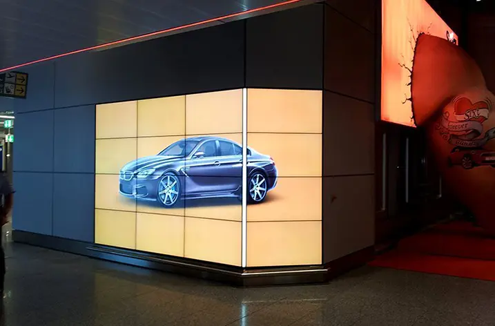 Großformatige LED-Wand mit einem Fahrzeugmotiv in einer Ladenpassage